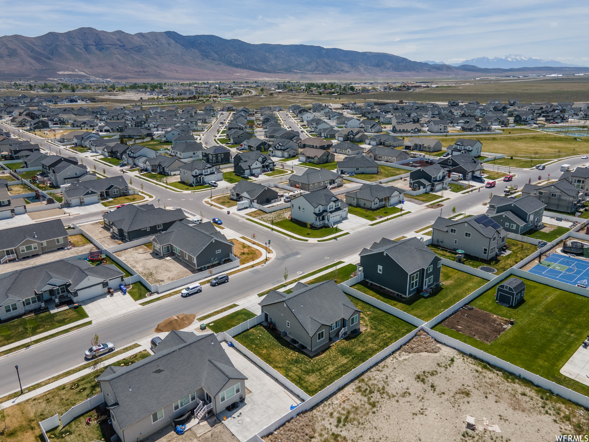 Aerial view of a new residential neighborhood in Eagle Mountain, Utah, with mountain backdrop